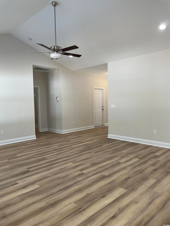 Empty room with ceiling fan, dark wood-type floori