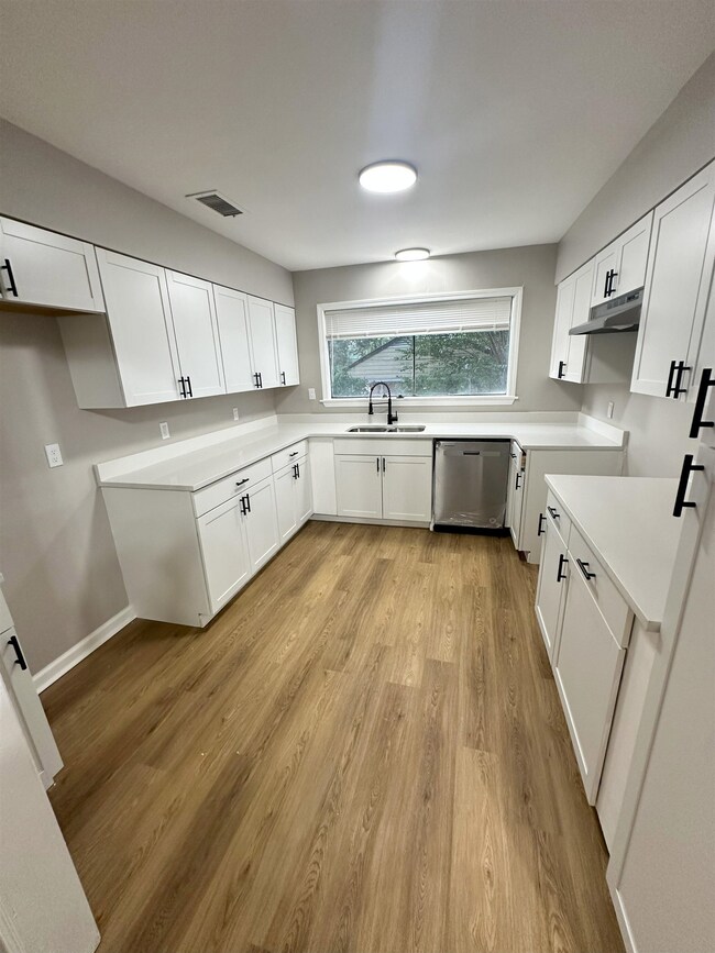 Kitchen featuring white cabinetry, stainless steel