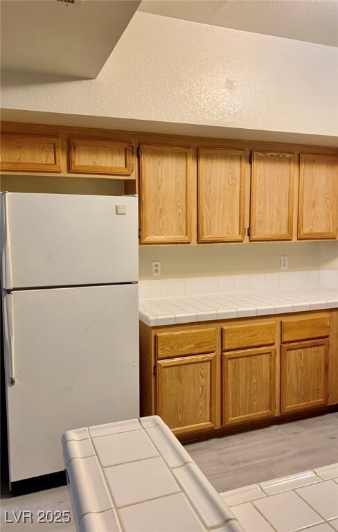 Kitchen with freestanding refrigerator and tile co