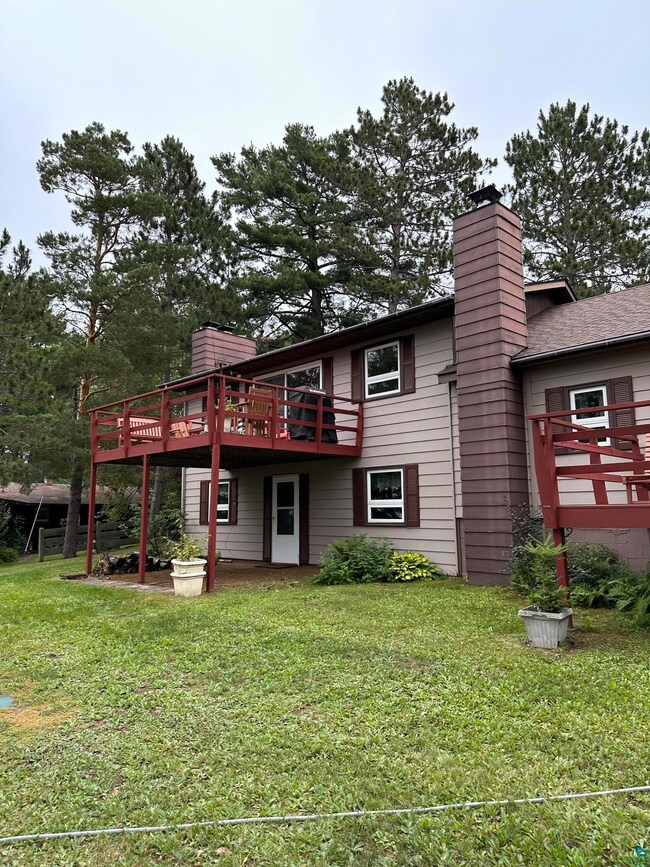 Rear view of house featuring a wooden deck and a l