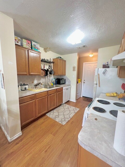 Kitchen with light wood-type flooring, visible ven