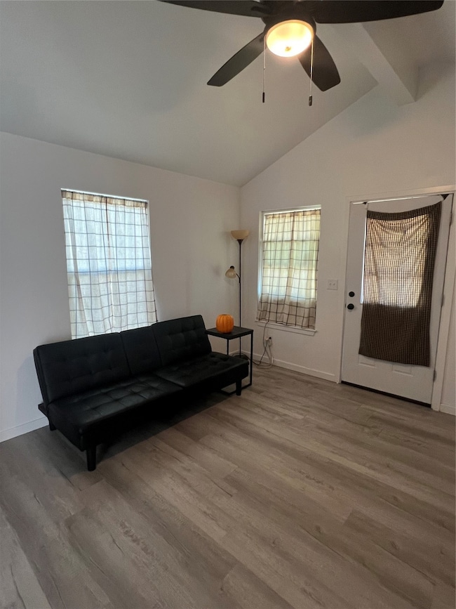 Living area with lofted ceiling, wood finished floors, and ceiling fan