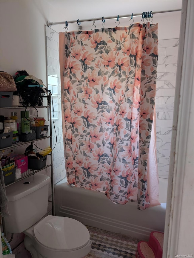 Bathroom featuring shower / bath combo and toilet