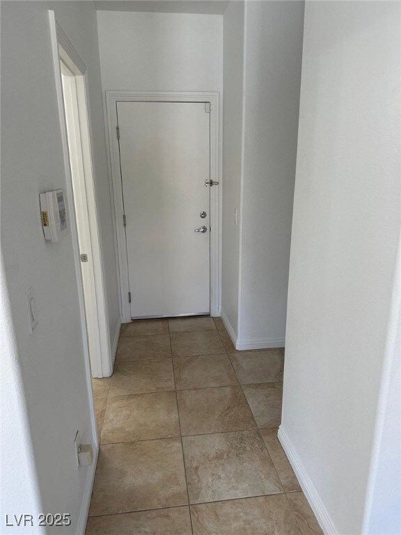 Corridor with baseboards and light tile patterned