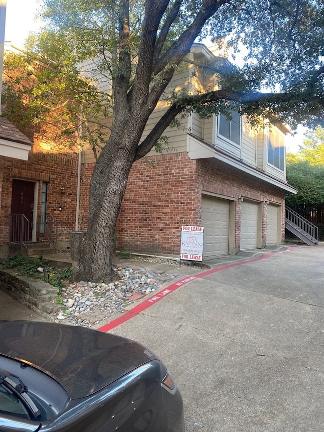 View of property exterior featuring an attached garage and brick siding