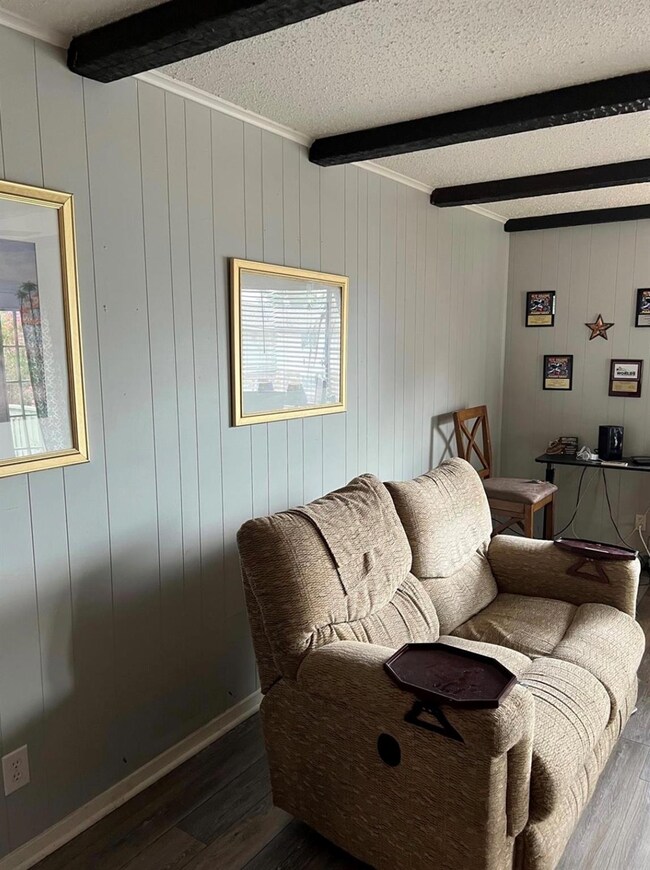 Living room with a textured ceiling, beam ceiling,