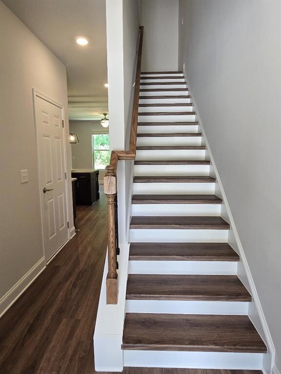 Staircase featuring wood finished floors and recessed lighting