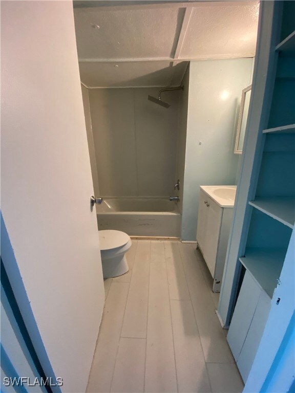 Full bathroom with tile patterned floors, vanity, toilet, and shower / washtub combination