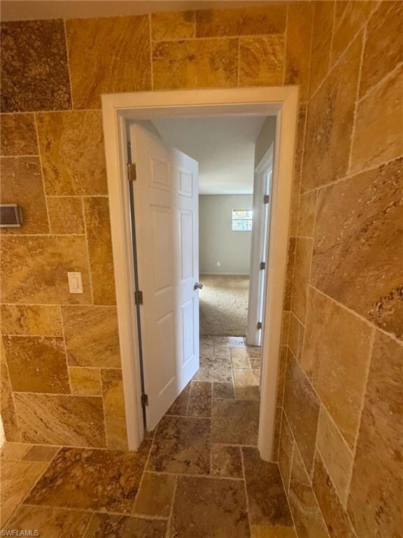 Hall featuring stone tile flooring