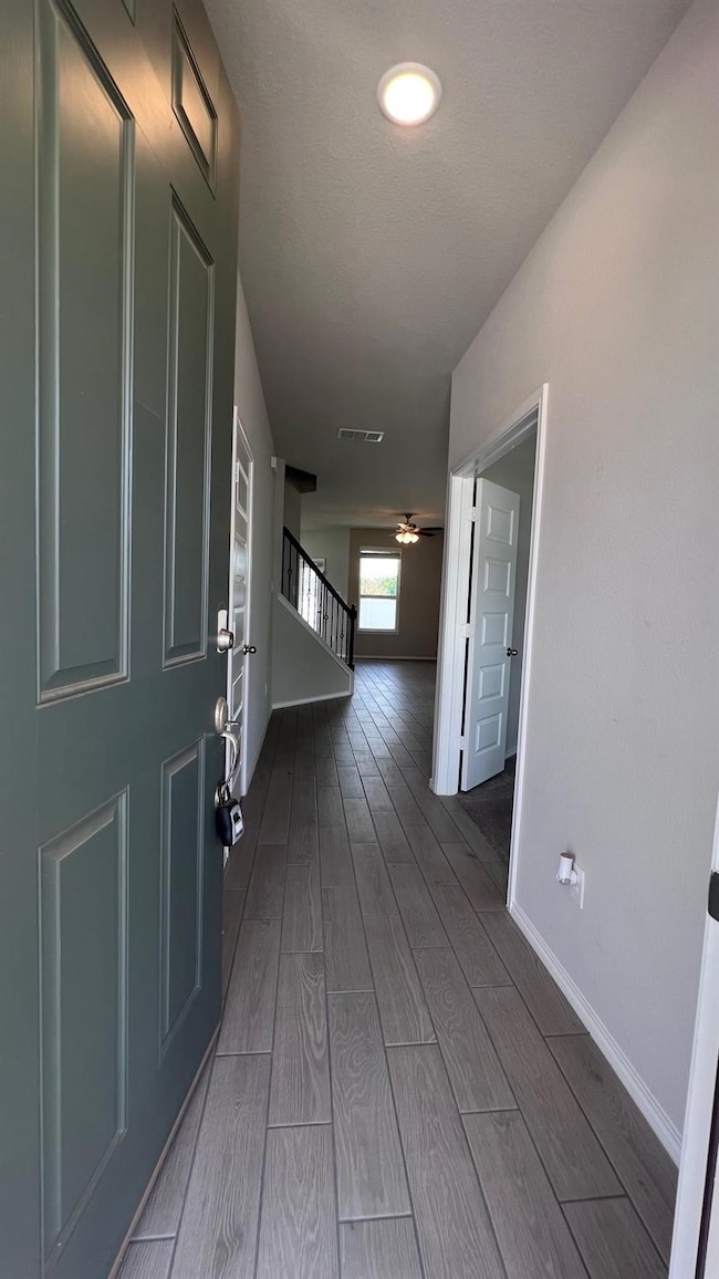 Corridor featuring wood finished floors and stairs