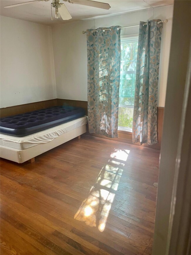 Unfurnished bedroom with wood-type flooring and ce