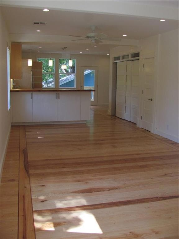 Empty room with light wood finished floors, a cei