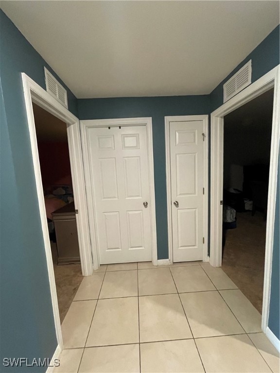 Hallway featuring light tile patterned floors and