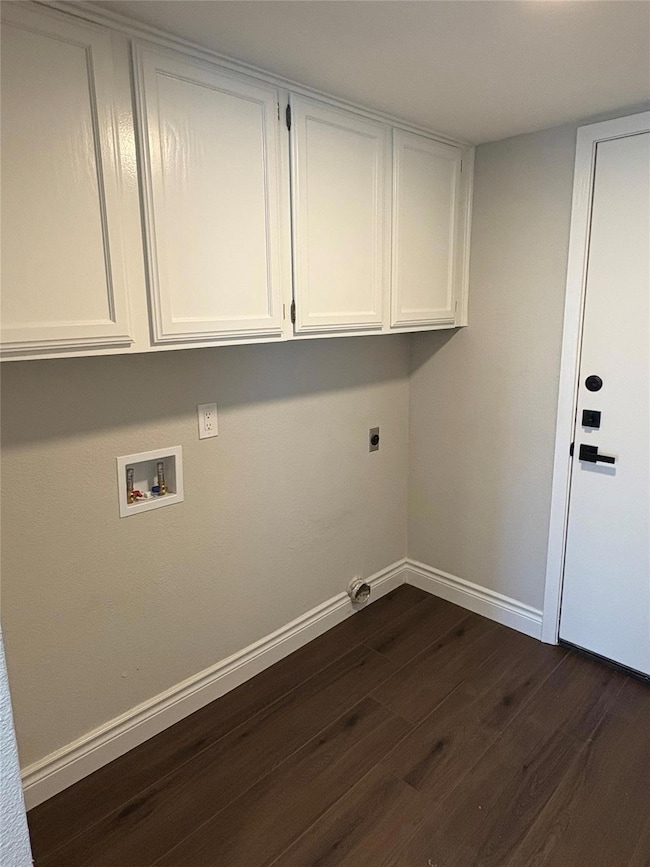 Clothes washing area with dark wood-style floorin