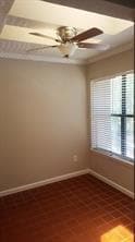 Unfurnished room with ceiling fan and brick patterned floors