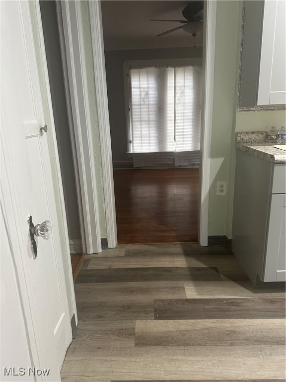 Corridor with light wood-style floors and baseboards