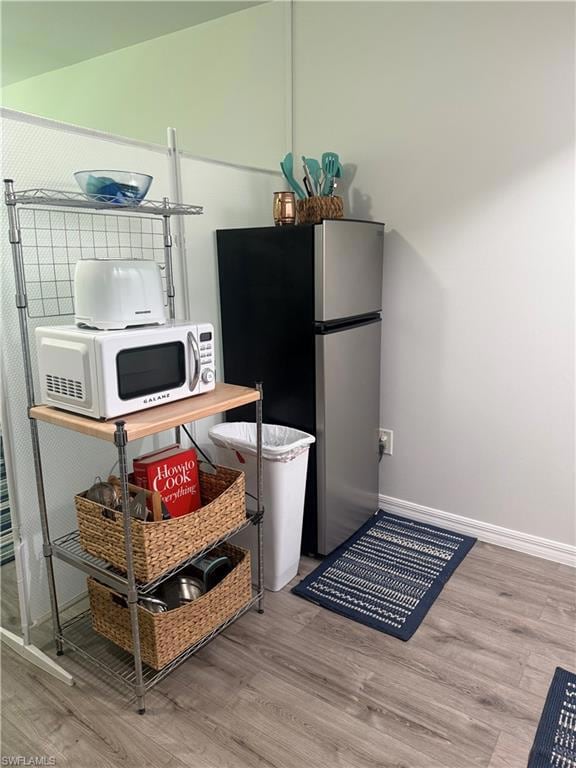 Kitchen featuring freestanding refrigerator and wood finished floors