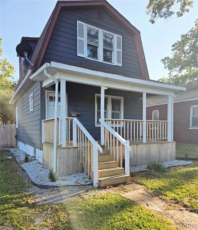 Dutch colonial featuring a gambrel roof and a porch