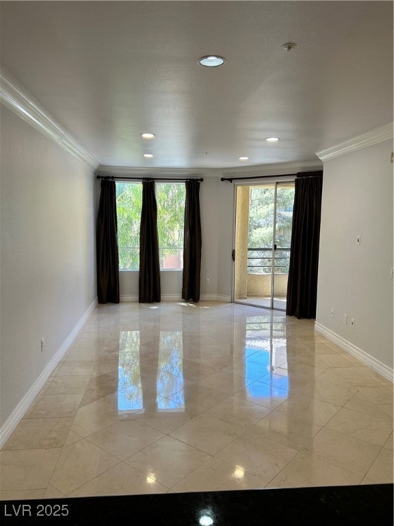 Empty room featuring ornamental molding, baseboard