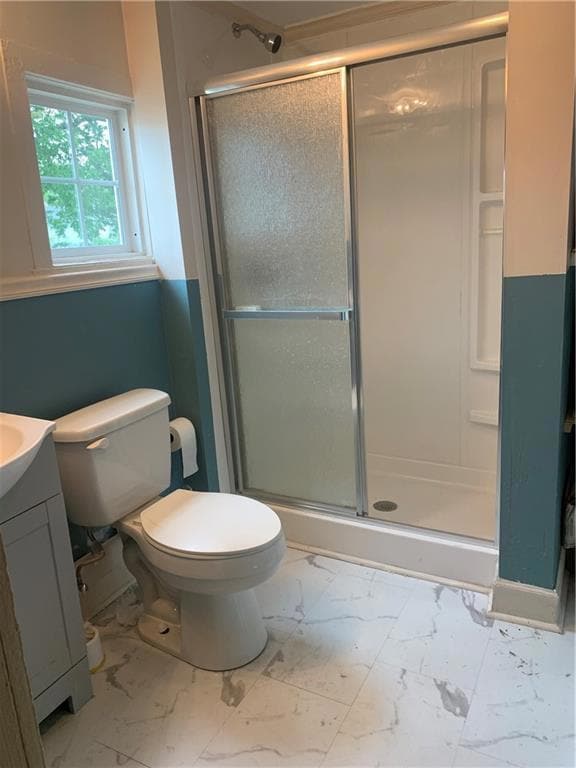Bathroom with vanity, walk in shower, and toilet