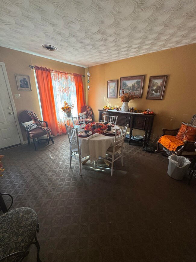 Carpeted dining room featuring a textured ceiling