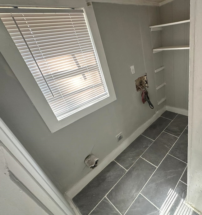 Washroom featuring hookup for an electric dryer and dark tile patterned floors
