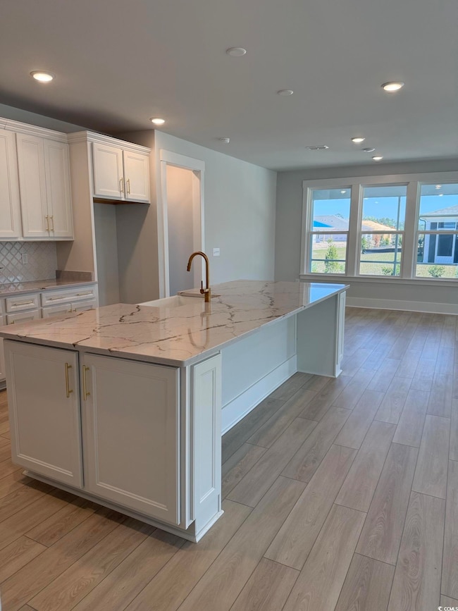 Kitchen featuring light wood-type flooring, white 