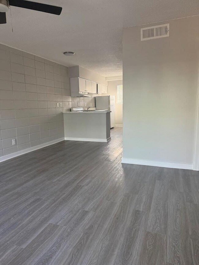 Unfurnished living room featuring dark wood-type 