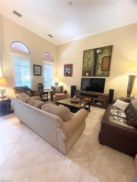 Living area featuring ornamental molding and light tile patterned floors