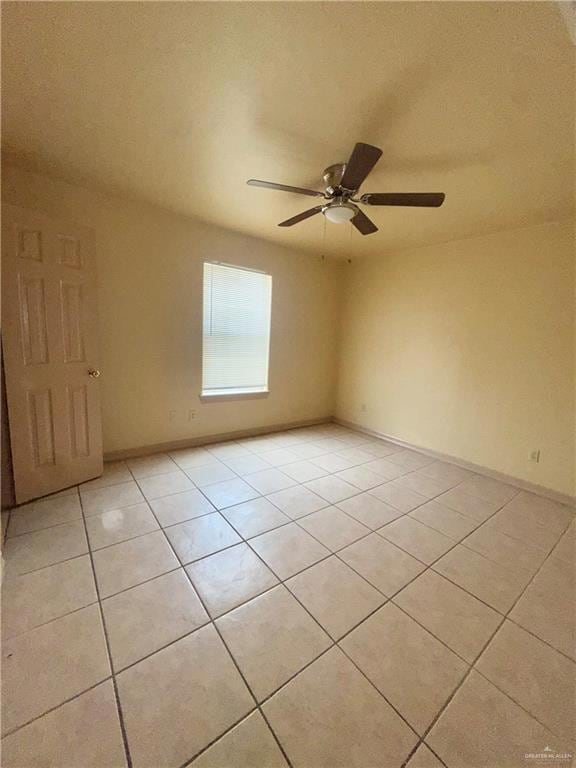 Unfurnished room featuring light tile patterned flooring and a ceiling fan
