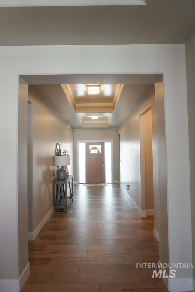 Entrance foyer with a tray ceiling and light wood-type flooring