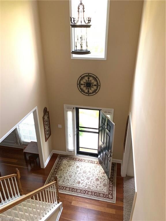 Impressive foyer with double stairs, one leads to front door, the other set of stairs leads to kitchen and Den area.