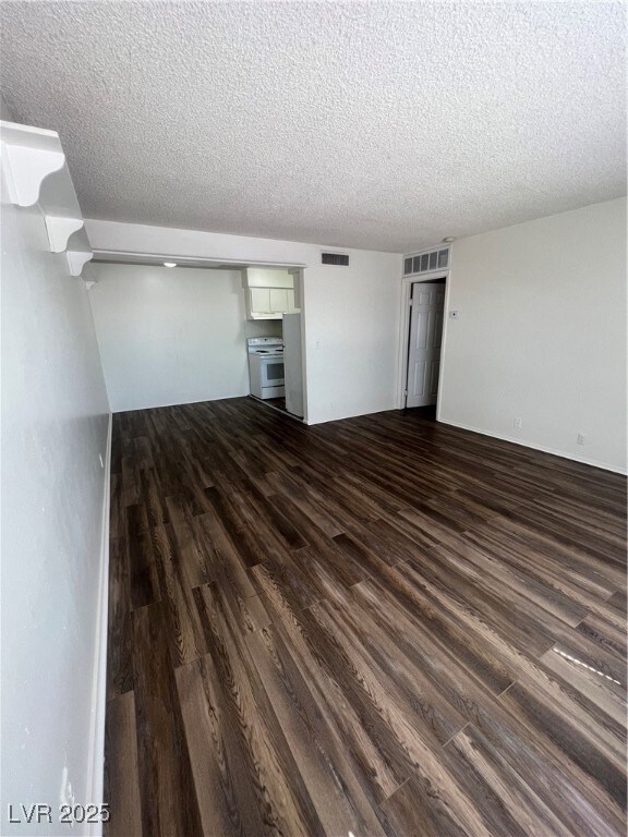 Unfurnished living room featuring a textured ceili