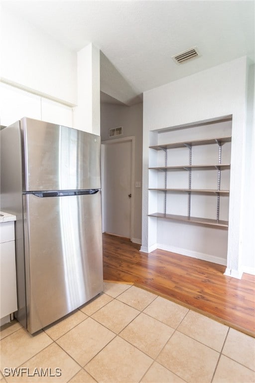 Kitchen with visible vents, white cabinets, freest