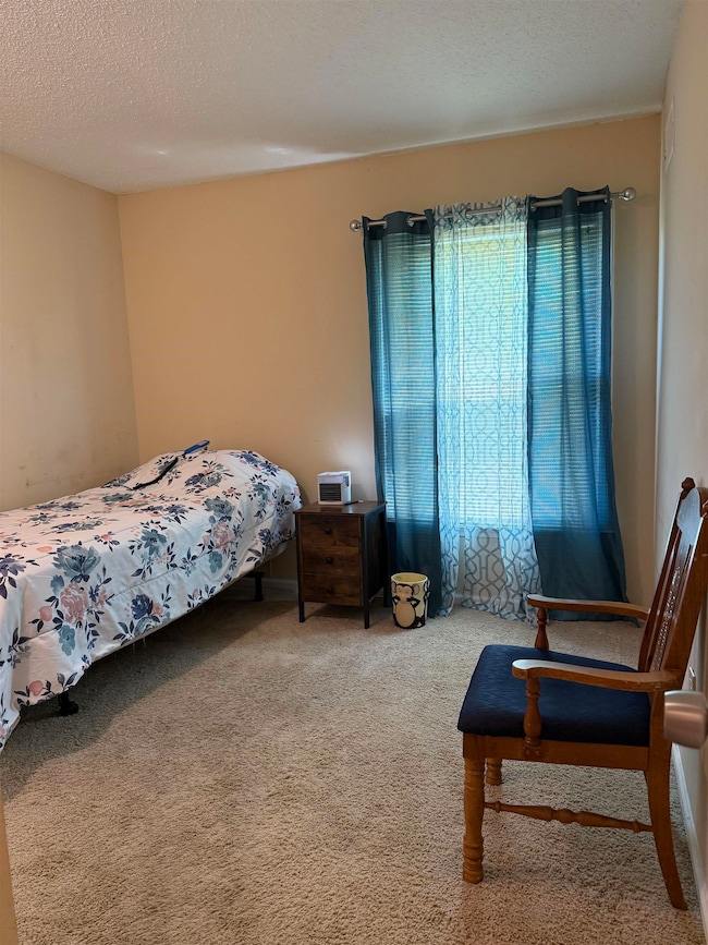 Carpeted bedroom featuring a textured ceiling