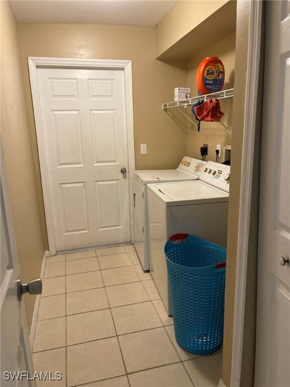 Clothes washing area featuring light tile patterne