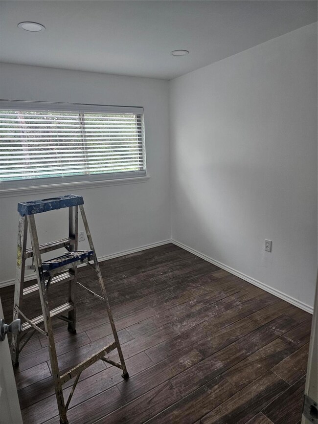 Spare room with dark wood-type flooring