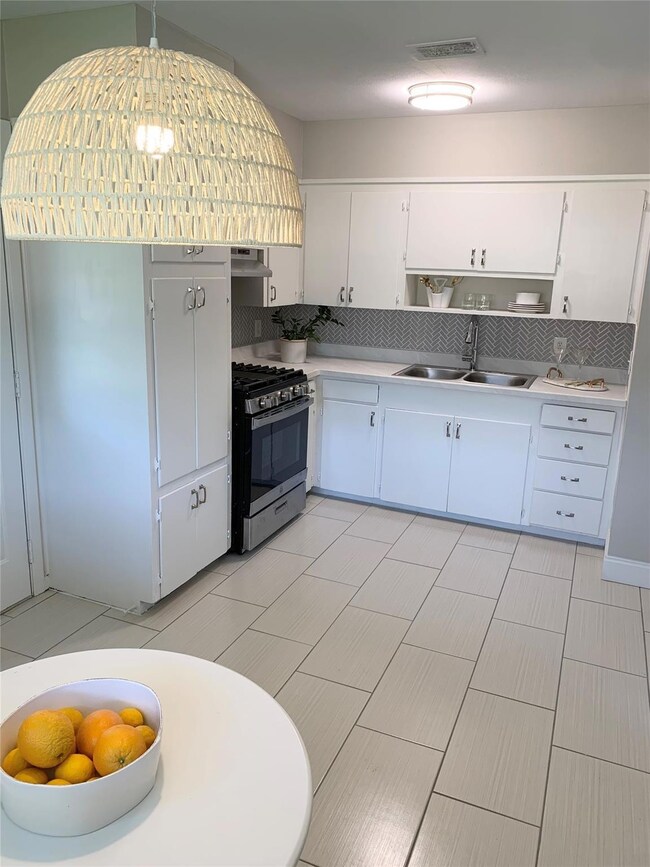 Kitchen featuring sink, exhaust hood, white cabine