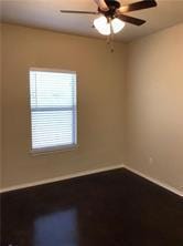 Unfurnished room featuring ceiling fan and baseboards