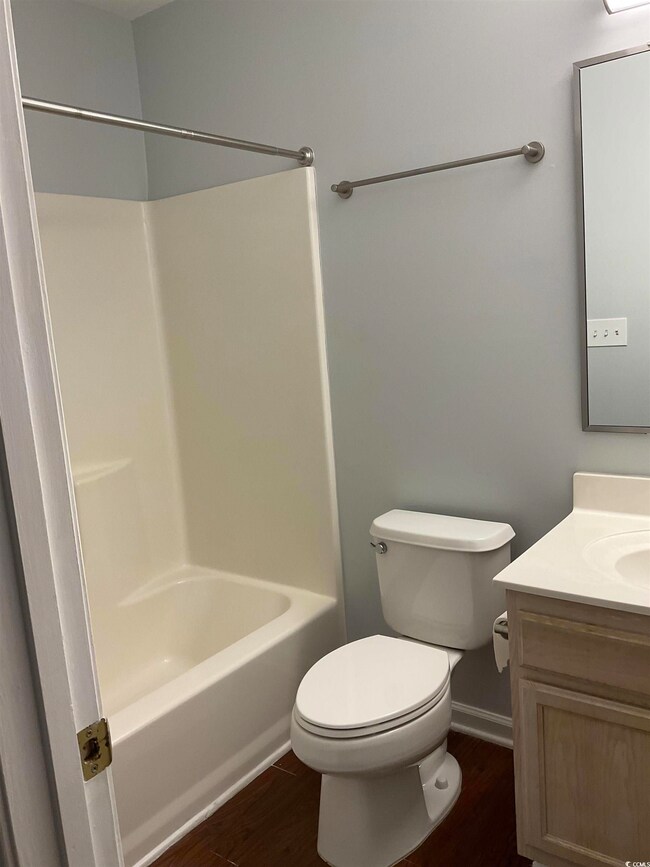Bathroom featuring vanity, wood finished floors, and bathing tub / shower combination