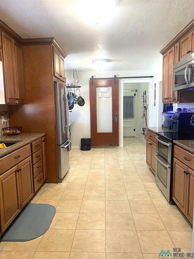 Looking toward the laundry room.  Area at end is a breakfast area. Antique barn door to laundry.