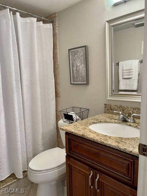 Bathroom featuring vanity, curtained shower, and light tile patterned floors