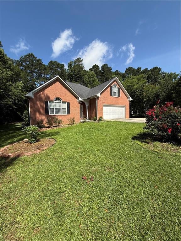 View of front of property featuring a front lawn, a garage, and driveway