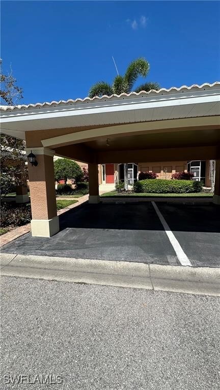 View of parking / parking lot with a carport