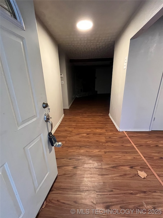 Hall with wood finished floors and baseboards
