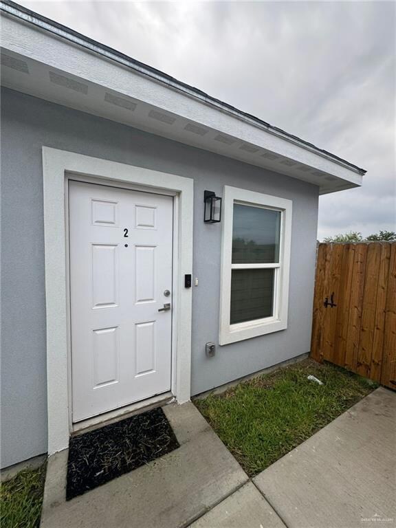 Entrance to property featuring stucco siding