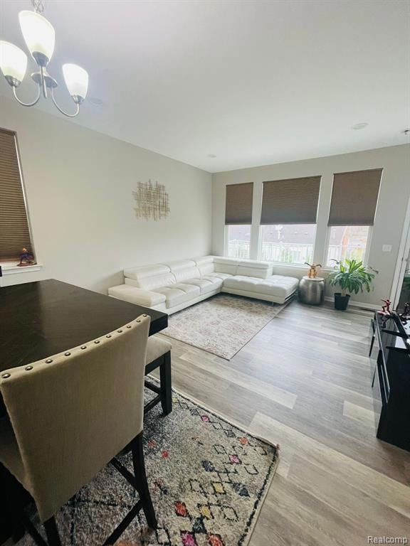 Living area with light wood-style floors and a chandelier