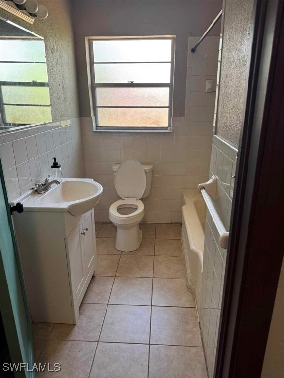 Bathroom featuring toilet, tile walls, vanity, wai