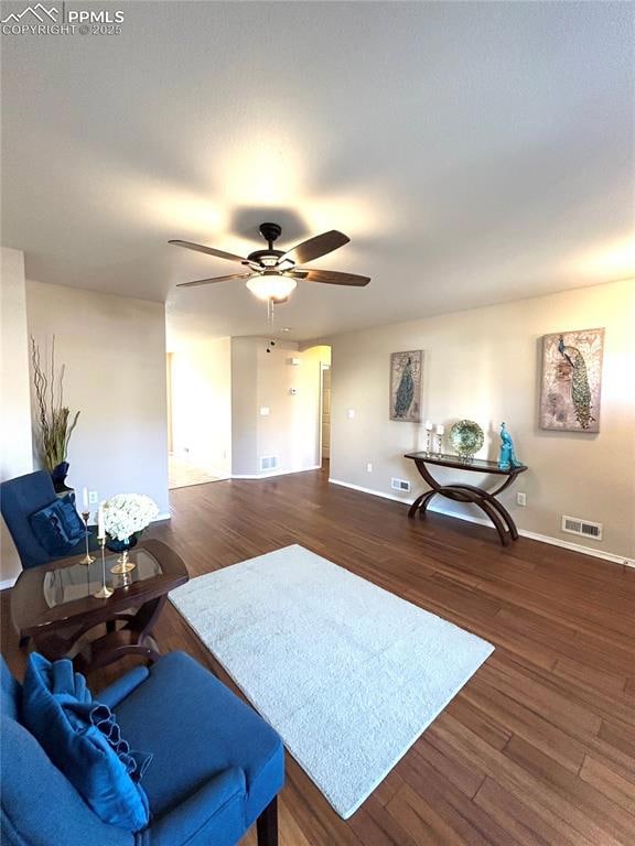 Living room with baseboards, ceiling fan, visible 