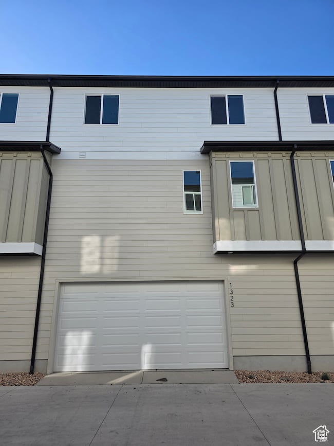 Rear view of house with a garage and concrete driveway